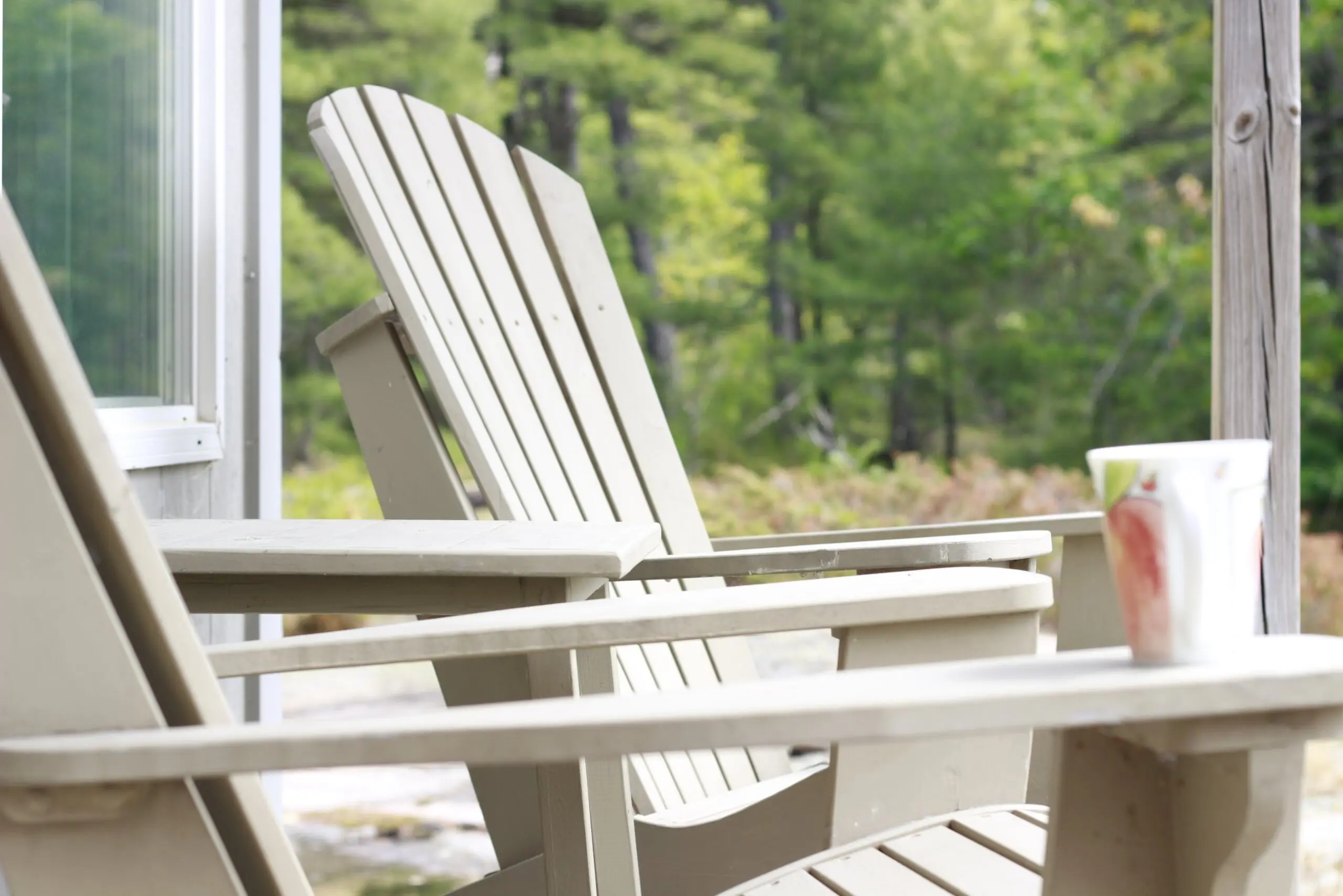 Adirondack chairs with cup on porch.