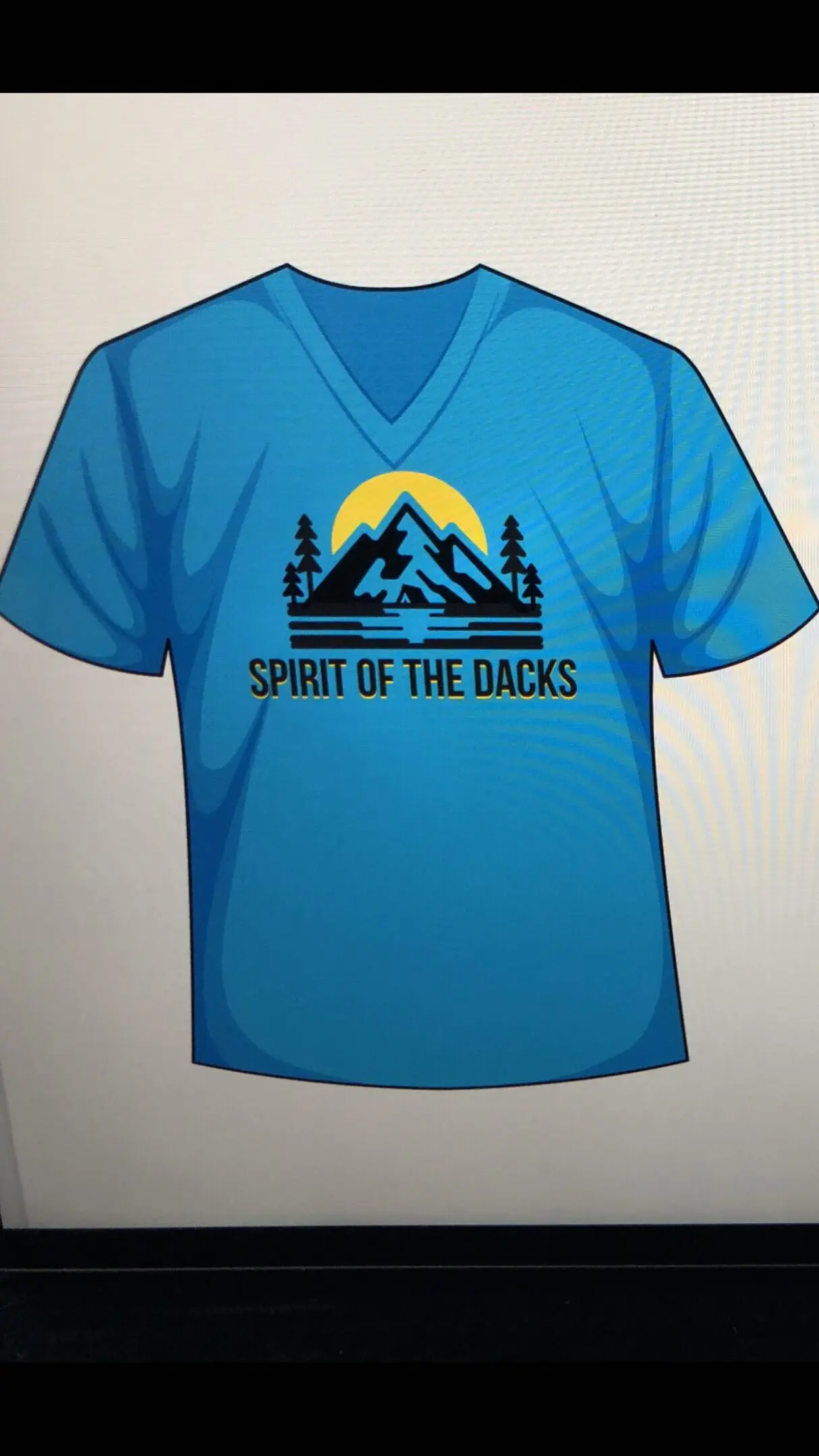 Blue t-shirt with mountain and lake graphic, text 'Spirit of the Dakotas'.