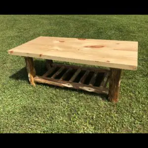 Rustic wooden coffee table with a slatted lower shelf on grass.