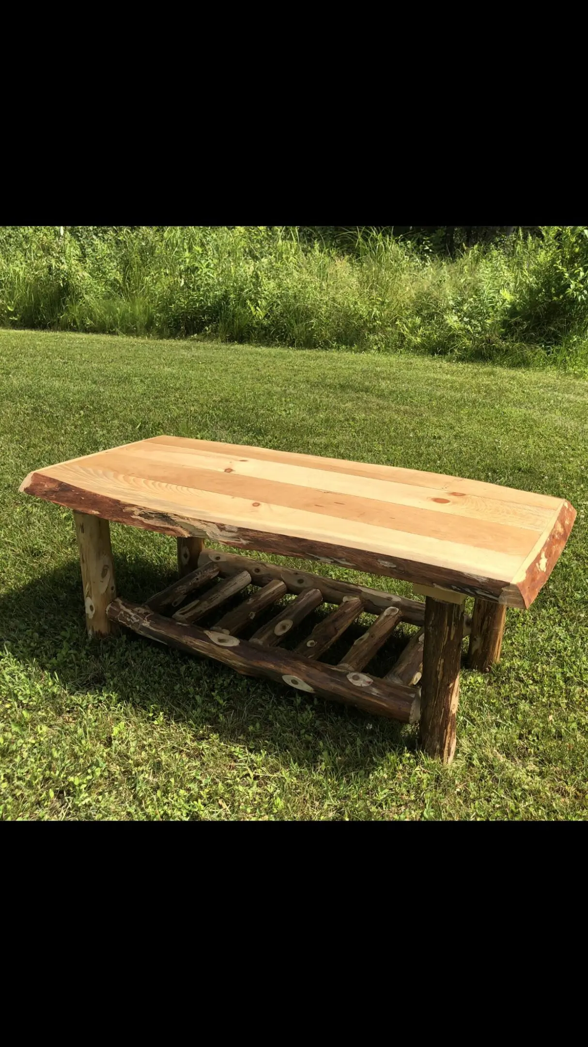 Rustic wooden bench with a natural wood finish and sturdy legs.
