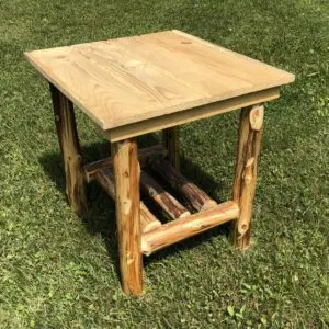 Rustic wooden side table with log legs on grass.