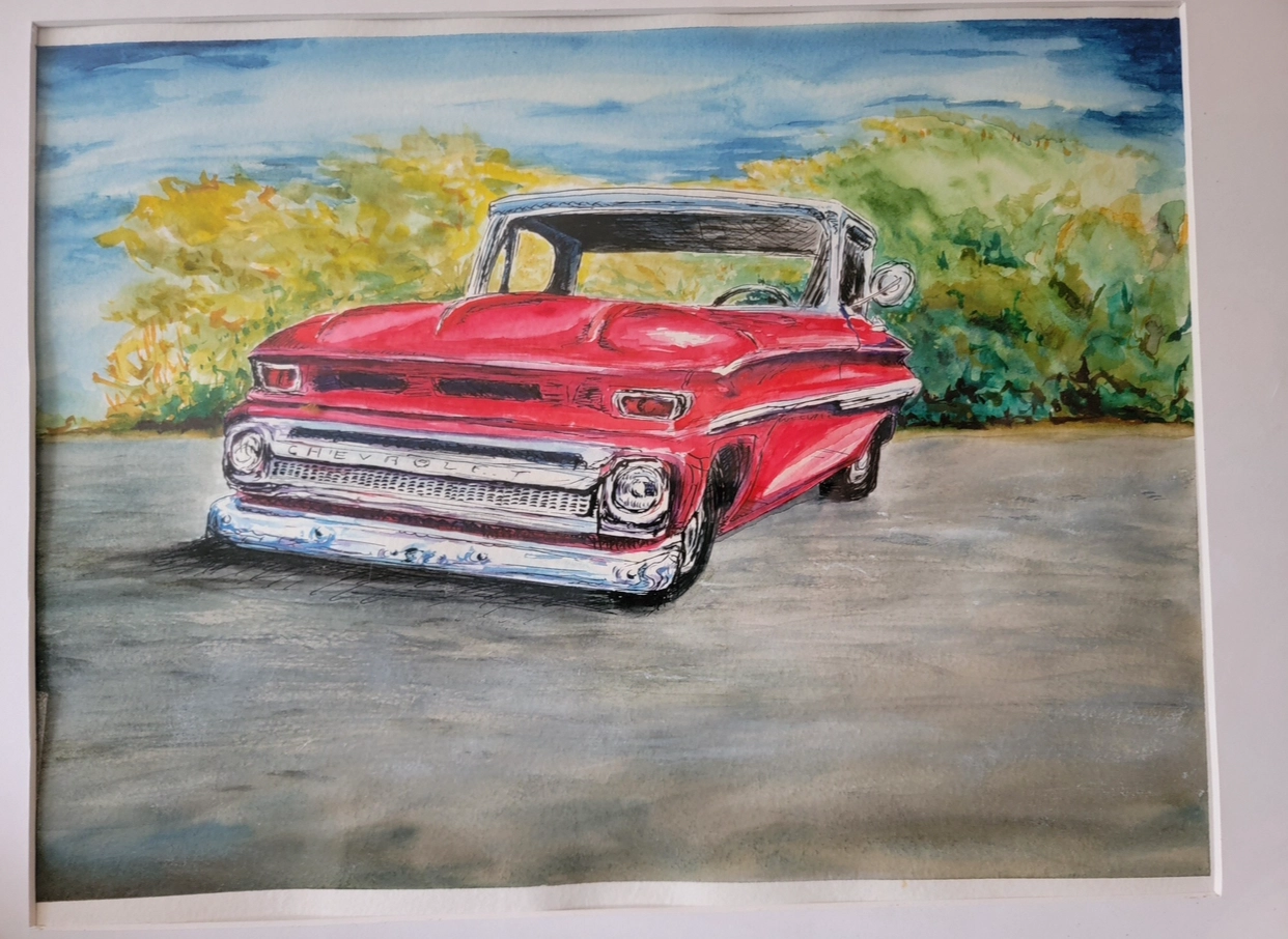 A vintage red car parked on a road with greenery in the background.