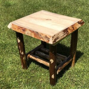 Rustic wooden side table with natural edges on grass.