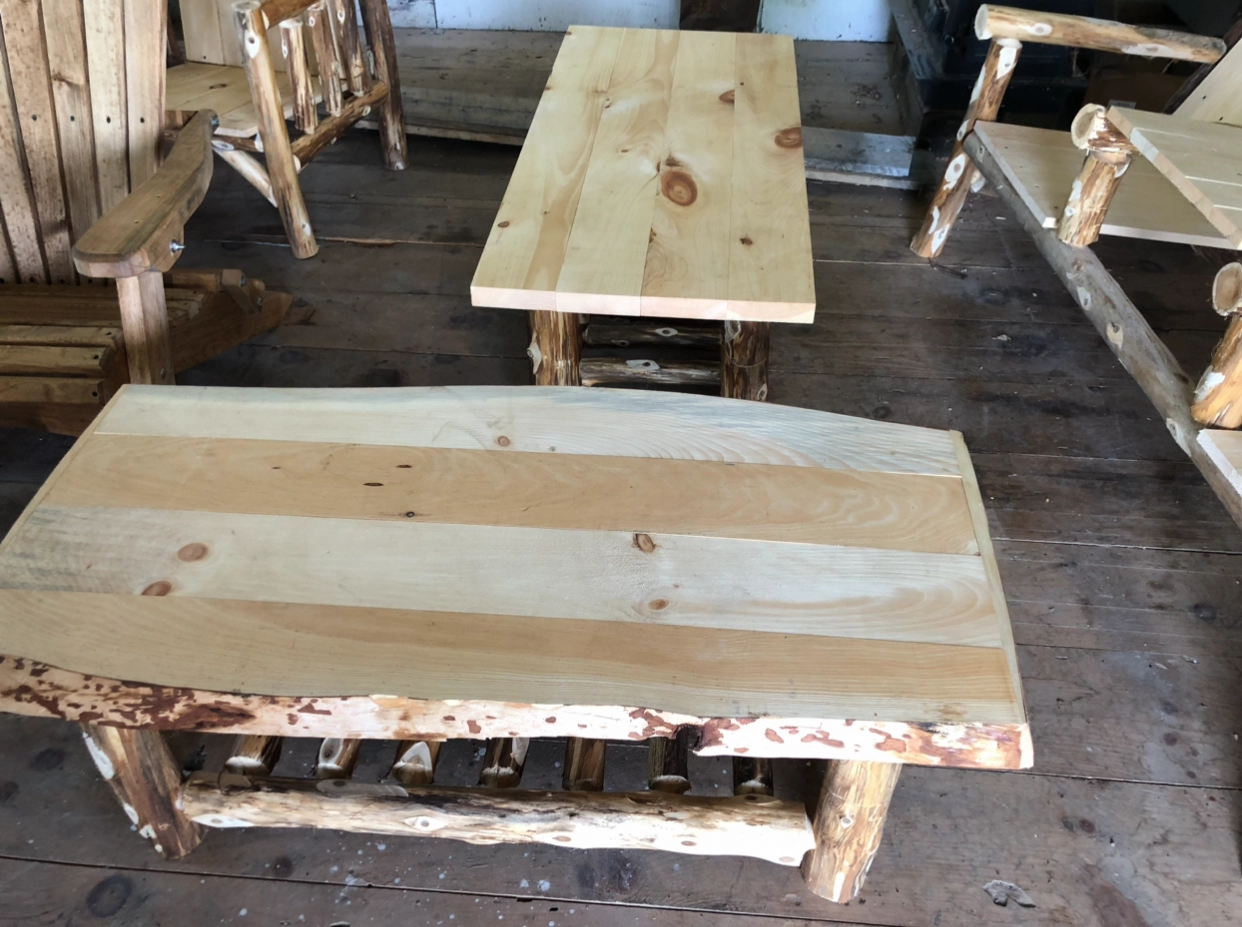 Rustic wooden tables made from natural planks and logs.
